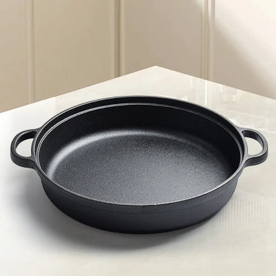 poele en fonte avec double poignee materiau sans sans substance toxique vide sur une table