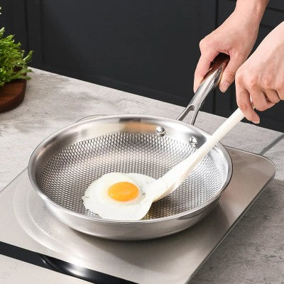 poele inox 18 10 sur plaque induction avec œuf au plat qui cuit