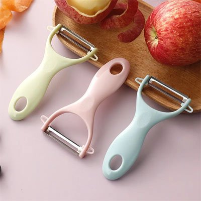Eplucheur trois sur une planche bois vert rose bleu