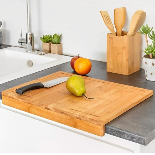 Planche à découper en bois sur bordure plan de travail avec poire et couteau