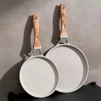 2 poele a crepes elegantes posees contre le mur manche en bois