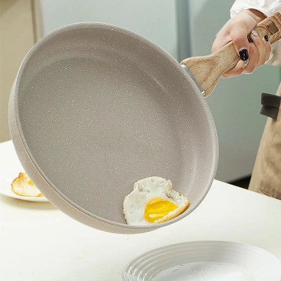 poele_en_revetement_ceramique_avec un oeuf au plat qui glisse dans une assiette