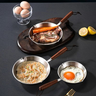 3 poeles inox 18 10 surnappe noire avec aliments dedans et oeuf das un bol
