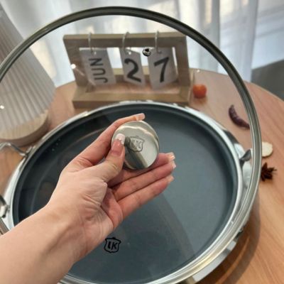 poêle inox 18 10 main qui tient le couvercle