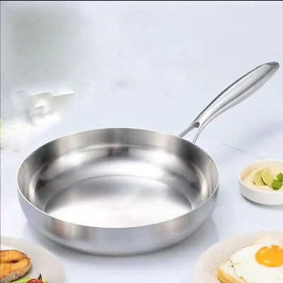 poele inox 18 10 seile sur plan de travail avec ingredients autour