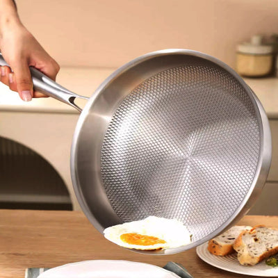 poêle inox induction oeuf au plat glissant dans assiette