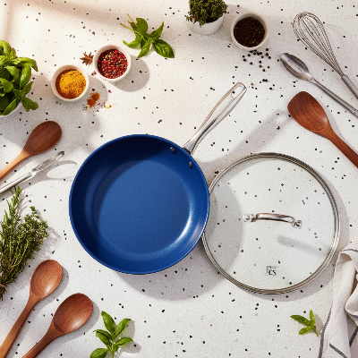 Poêle inox induction couvercle verre trempé vus de haut avec décor épices autour